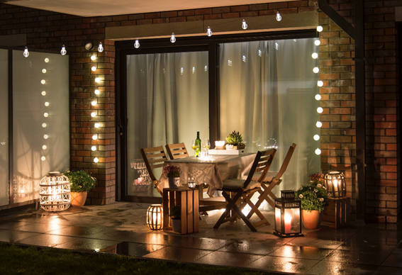 terraço iluminado com lanternas, decorado com mesa e cadeiras