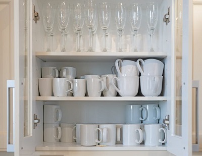 canacas e copos de champanhe em armário de cozinha organizado