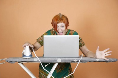 mulher em casa com tábua de engomar e computador