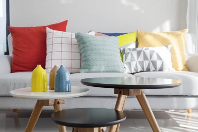 sofá com almofadas coloridas e mesas de apoio