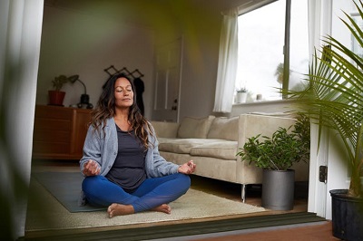 mulher a praticar yoga na sala de estar