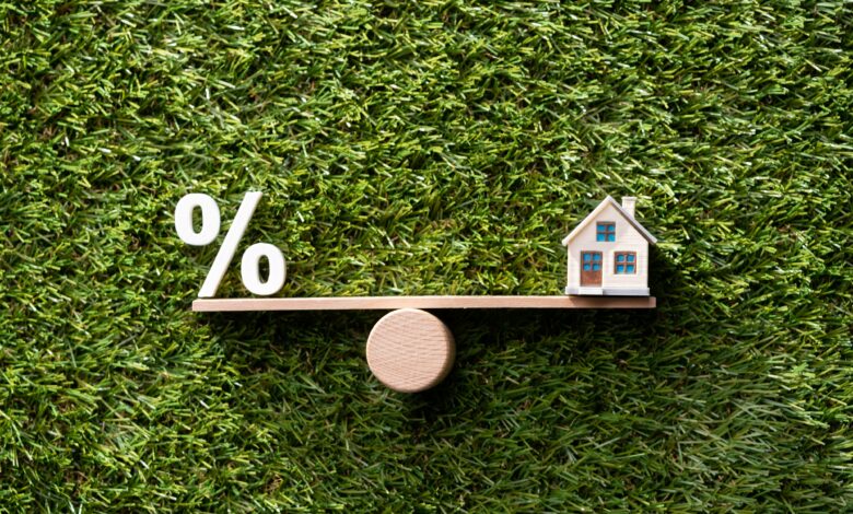 Balança em equilíbrio com ícone de percentagem à esquerda e uma casa à direita, fazendo referência à escolha entre taxa fixa ou taxa variável na contratação do crédito habitação